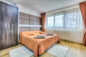 a bedroom with a bed and a large window at Splendor in the forest in Braşov