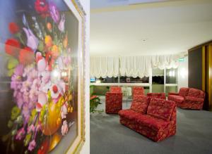 カオルレにあるHotel Metropolの赤い椅子と絵画が飾られた待合室