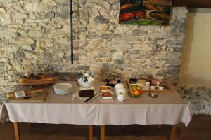 a table with food on it with a stone wall at Le Mas de roux Chambres d'hotes in Bragassargues