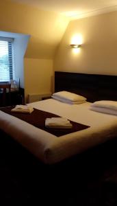 a bedroom with a large bed with towels on it at The Brent Hotel - London - Wembley in London