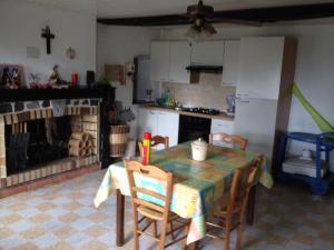 a kitchen with a table and chairs and a fireplace at Le Clergite in Clairfayts