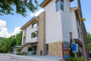 a large white building with a brick at Hotel & Relax Zone Cattleya in Krushuna