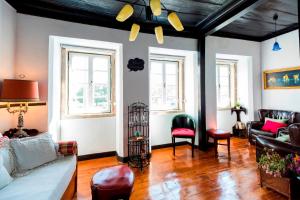 una sala de estar con un sofá y sillas en Atelier - House in Belém, en Lisboa