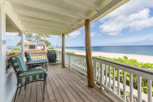 veranda con sedie, tavolo e spiaggia di Pipe Beach House a Pupukea