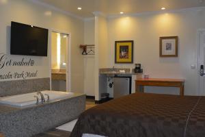 a bedroom with a bed and a tub and a television at Lincoln Park Motel in Los Angeles