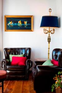 uma sala de estar com duas cadeiras de couro e um candeeiro em Atelier - House in Belém em Lisboa