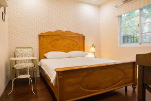 ein Schlafzimmer mit einem Holzbett und einem Fenster in der Unterkunft Mallorca Homestay in Hualien