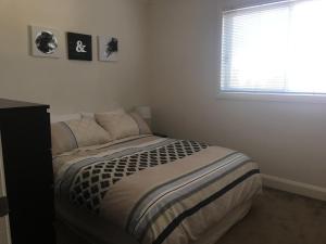 a bedroom with a bed with pictures on the wall at Travers Street Apartment in Wagga Wagga