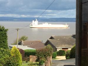 a large white ship in the water with houses at The Nook @ Drop Anchor in Portishead