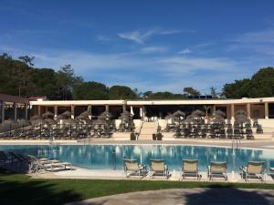 a swimming pool with chairs and a building at Quinta do Lago Golf in Quinta do Lago