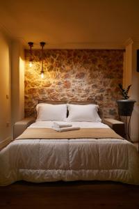 a bedroom with a large bed with a brick wall at warm stone house in Athens