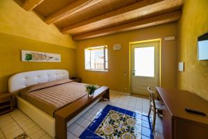 シラクーサにあるHotel Casale Miloccaのベッドルーム1室(ベッド1台、デスク、窓付)