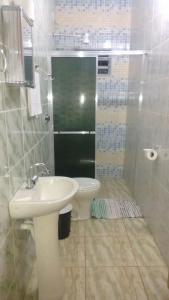 a bathroom with a sink and a shower with a toilet at Pousada Rancho do João in Pirenópolis