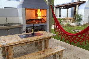 a picnic table with a fireplace and a hammock at Alma de La Pedrera - in La Pedrera