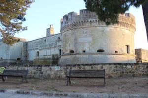 two benches sitting in front of a castle at Casa Assuntina in Acaya