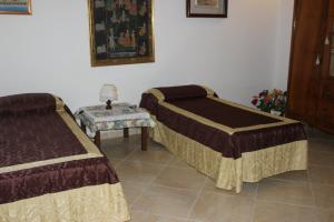 アカイアにあるCasa Assuntinaのベッド2台とサイドテーブルが備わる客室です。