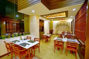 a restaurant with tables and chairs in a room at King Park Hotel in Mandalay