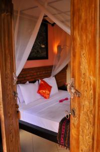 Postel nebo postele na pokoji v ubytování Tirta Sari Bungalow