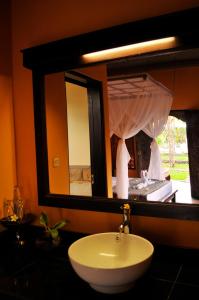 łazienka z umywalką i dużym lustrem w obiekcie Tirta Sari Bungalow w mieście Pemuteran