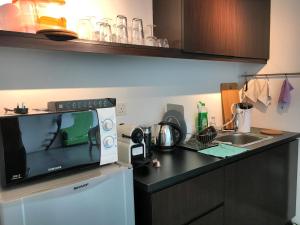 eine Küche mit Mikrowelle und Spüle in der Unterkunft 2Stories Empire Duplex at Damansara Perdana in Damansara Perdana