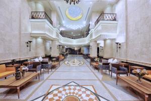 - un hall d'un hôtel avec des tables et des chaises dans l'établissement Spectrums Residence Jeddah, à Djeddah