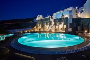 ein Schwimmbad vor einem Gebäude bei Nacht in der Unterkunft Aperanto Suites in Oia