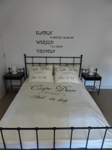 Una cama con escritura encima. en B&B Carpe Diem, en Maaseik