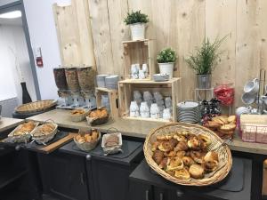 a counter with a bunch of different types of bread at Kyriad Direct Agen in Castelculier