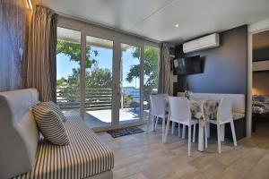 a living room with a table and chairs and a dining room at Oaza Mira Camping in Drage
