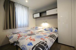a bed room with a white bedspread and pillows at Oaza Mira Camping in Drage