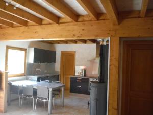 a kitchen with a table and chairs in a room at Les brimbelles in Gérardmer