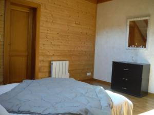 una camera con un grande letto e una parete in legno di Les brimbelles a Gérardmer