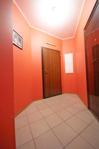 a hallway with orange walls and a door at Apartments at Nekrasova 8 in Abakan