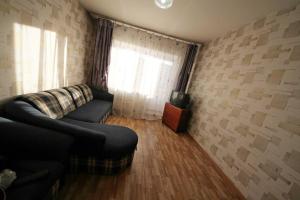 a living room with a couch and a television at Apartments at Nekrasova 8 in Abakan