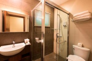 a bathroom with a shower and a sink and a toilet at Swiss Hotel Apartment in Kuala Belait