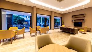 a waiting room with yellow chairs and tables and windows at Ada Julian Marmaris in Marmaris