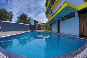 a swimming pool in front of a house with a building at Highland Resort in Lonavala