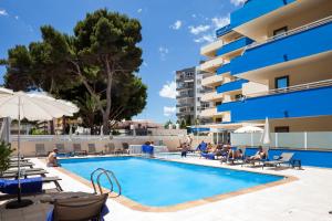 a pool at a hotel with people sitting around it at Ibiza Heaven Apartments in Playa d'en Bossa