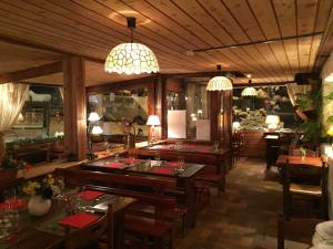 un restaurante con mesas de madera, sillas y luces en Hotel Franz en Allos