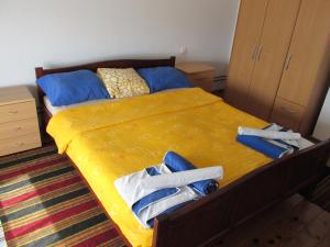 a bedroom with a yellow bed with towels on it at Country House Roman in Doboj +27 photos