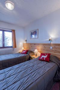 una camera d'albergo con due letti e un divano di Hotel Franz ad Allos