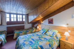 sypialnia z łóżkiem i drewnianym sufitem w obiekcie Hotel Franz w mieście Allos