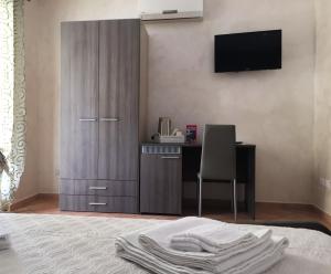 a bedroom with a bed with a desk and a television at Residenza Dama in Santa Domenica