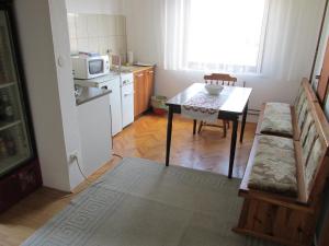a small kitchen with a table and a microwave at Country House Roman in Doboj