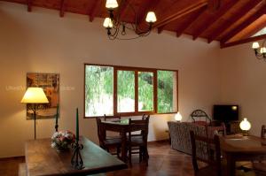 a living room with a table and chairs and a window at Leyenda Posada in Capilla del Monte