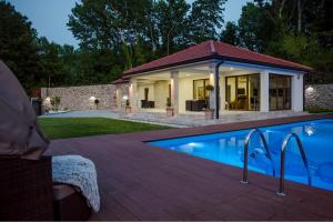 a home with a swimming pool and a house at Villa Karla in Međugorje