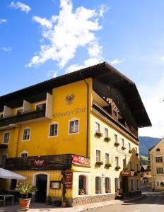 ein gelbes Gebäude an der Straßenseite in der Unterkunft Hotel Schwarzer Adler Sillian in Sillian