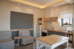 a kitchen with a table and a couch and a table at Artemis Village Apartments & Studios in Stavros