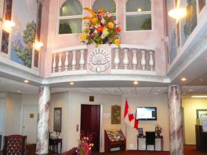 eine Lobby mit einem Balkon mit Blumen darauf in der Unterkunft Coast Abbotsford Hotel & Suites in Abbotsford