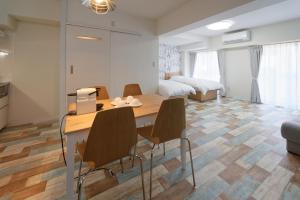 una habitación con mesa y sillas y un dormitorio en Wallaby House en Kawaguchi